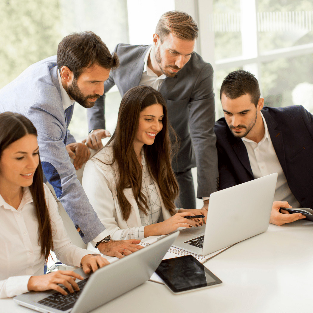 A group of people discussing by seeing laptops